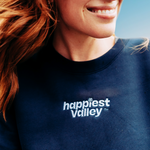 https://bonafidephoto.com Photo of @happyvalleyhannah smiling while wearing navy crew neck sweater with white embroidered logo 'happiest valley.' Perfect for Penn State fans and nostalgia for good times in happy valley / State College, PA