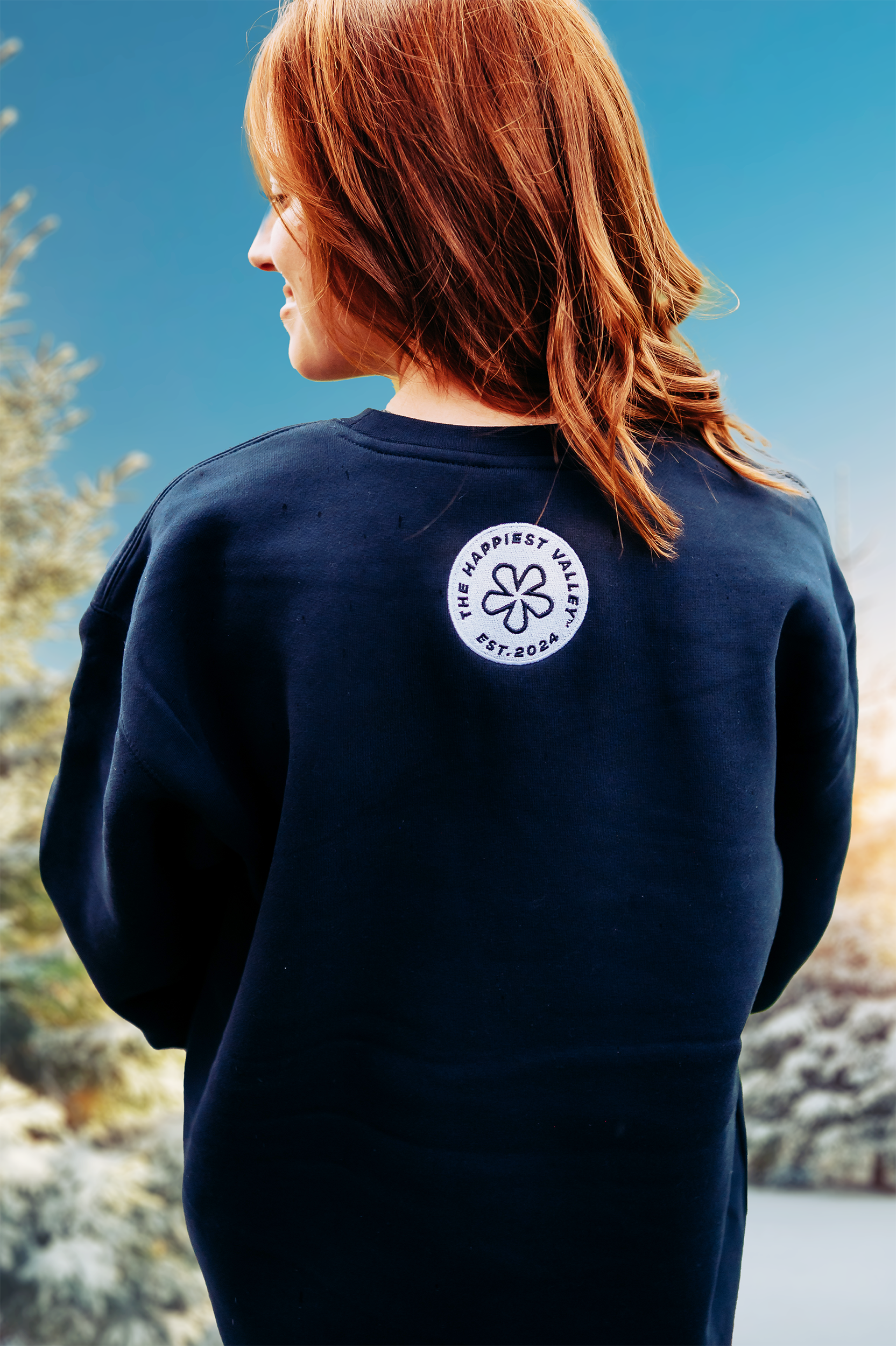 https://bonafidephoto.com Photo of @happyvalleyhannah wearing navy crew neck sweater with white embroidered badge logo 'the happiest valley, established 2024' Perfect for Penn State fans and nostalgia for good times in happy valley / State College, PA