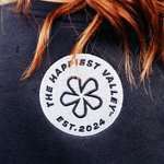 https://bonafidephoto.com Photo of @happyvalleyhannah wearing navy crew neck sweater with white embroidered badge logo 'the happiest valley, established 2024' Perfect for Penn State fans and nostalgia for good times in happy valley / State College, PA